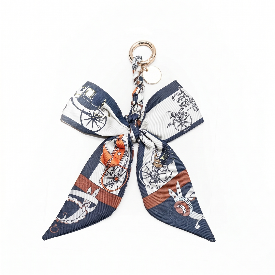 Navy carriage print fabric bow bag charm on a gold clasp