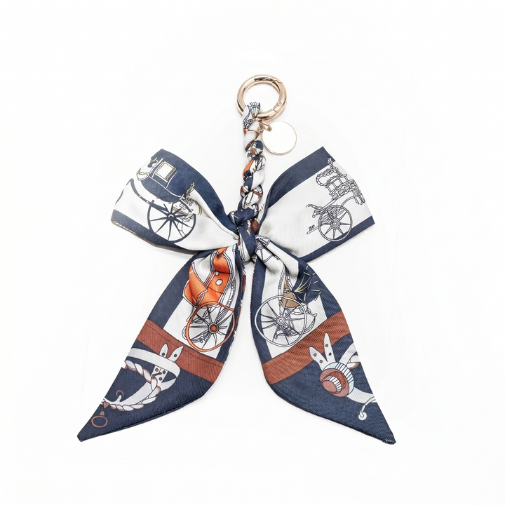 Navy carriage print fabric bow bag charm on a gold clasp