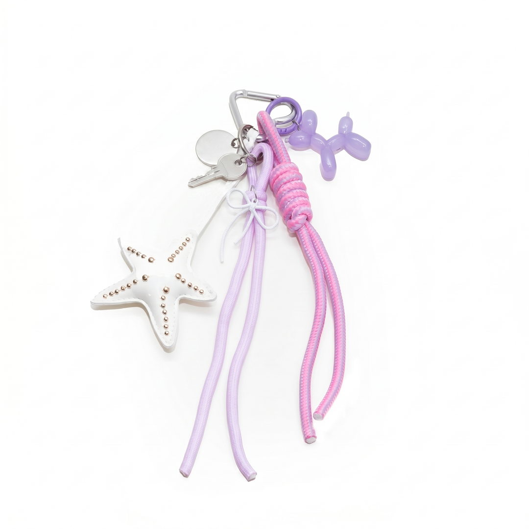 Purple starfish bag charm with a balloon dog, key and braided cords