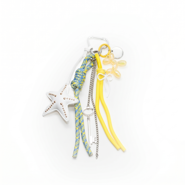 White starfish bag charm with a yellow balloon dog, key and braided cords