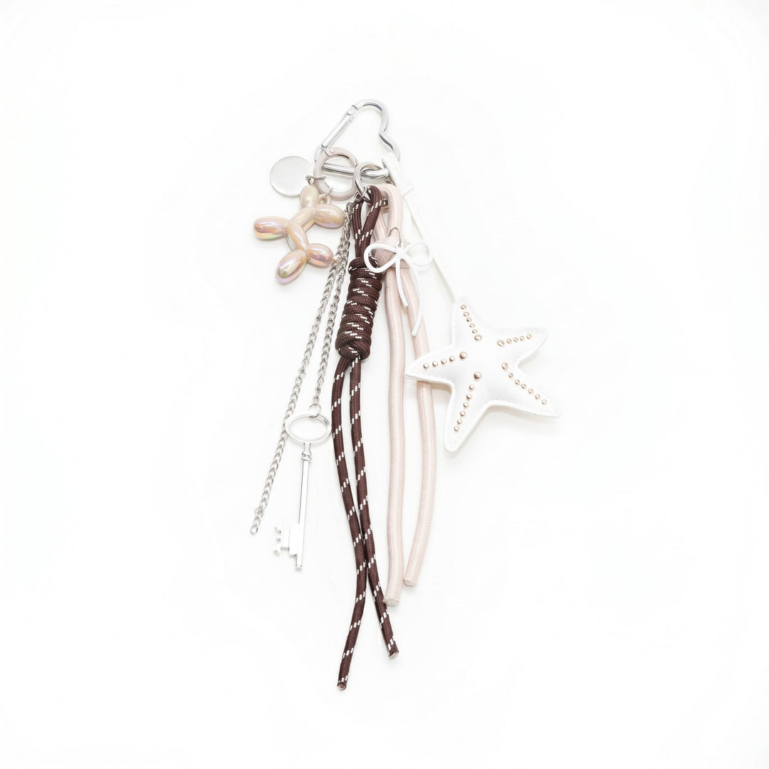 Beige starfish bag charm with a balloon dog, key and braided cords