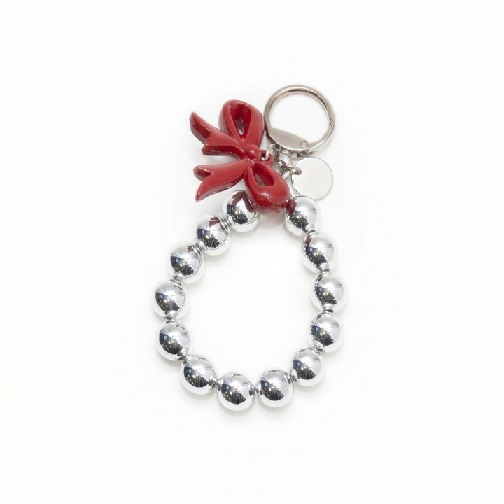 Silver beaded loop bag charm with a glossy red bow