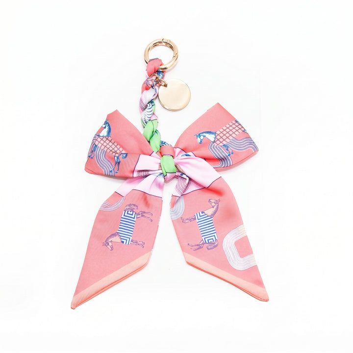 Pink horse print fabric bow bag charm on a gold clasp