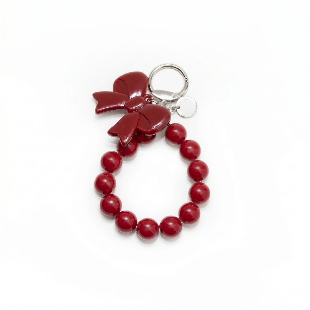 Red beaded loop bag charm with a glossy red bow