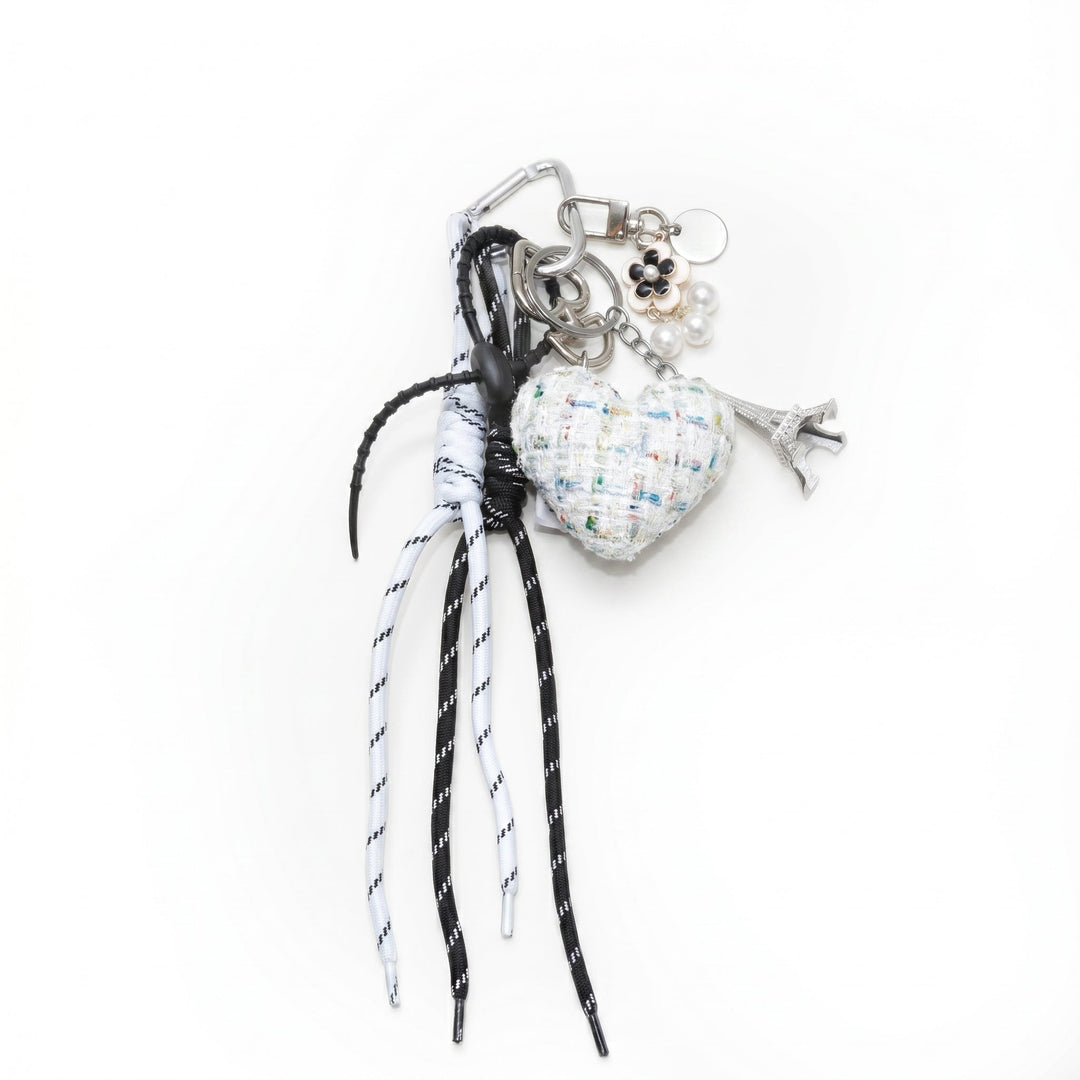 White tweed padded heart bag charm with cords and an Eiffel Tower charm