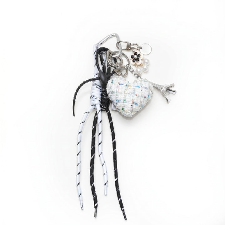 White tweed padded heart bag charm with cords and an Eiffel Tower charm
