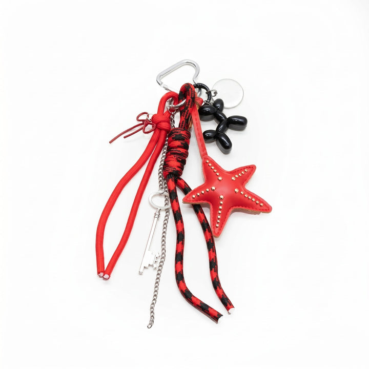 Red starfish bag charm with a black balloon dog, key and braided cords